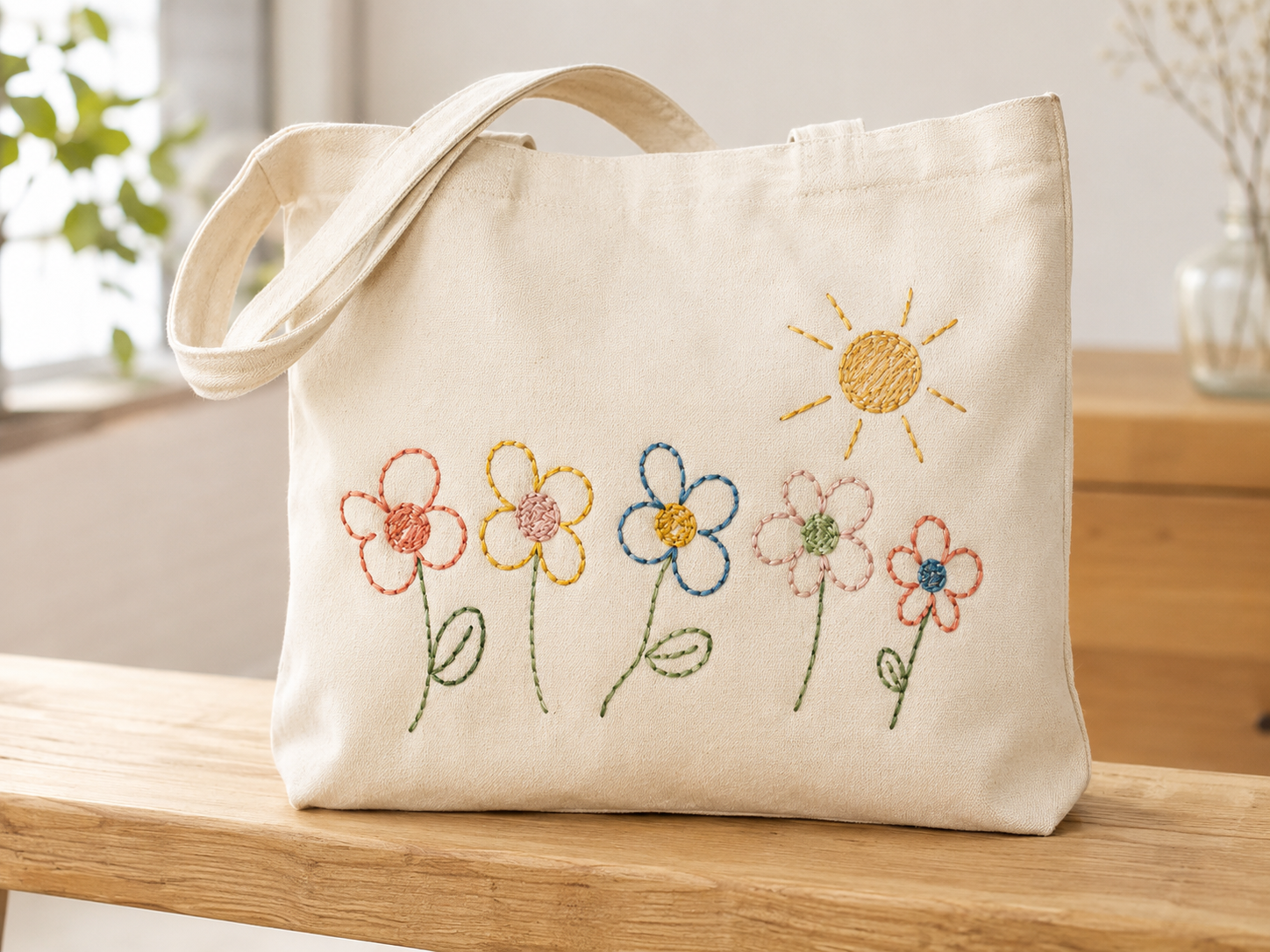 生成りのキャンバストートに、子どもが描いた花と太陽の絵を線のまま刺繍したもの